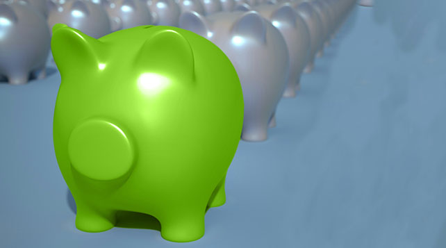 group of piggy banks that are silver with one bright green piggy bank in front