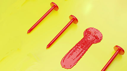 4 red nails on a yellow background. One nail is flattened.