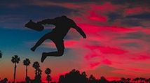 man jumping in the dark sunset